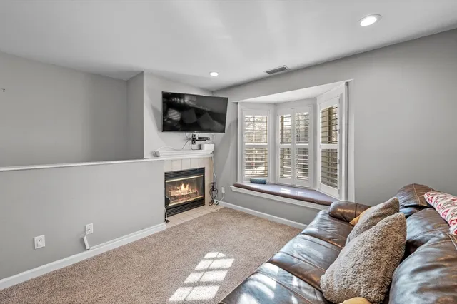 a living room with furniture a flat screen tv and a fireplace
