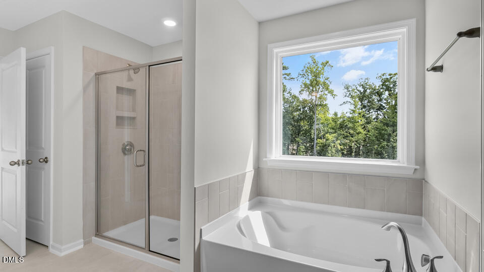 142 Red Jasper Way Clayton, NC 27520 - Photo 26 of 36 a white bath tub sitting next to a shower