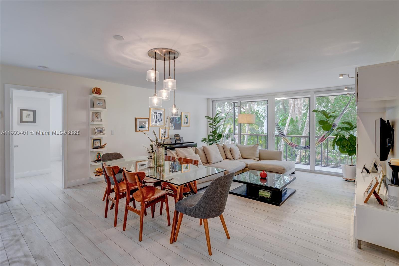 a view of a dining room with furniture a chandelier and wooden floor