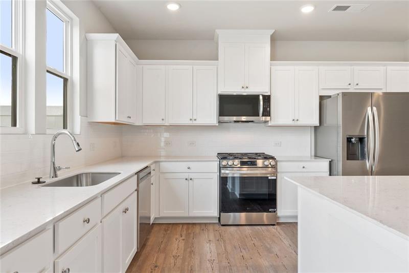 1303 Farmers Loop Austell, GA 30106 - Photo 7 of 21 a kitchen with a sink stove and refrigerator