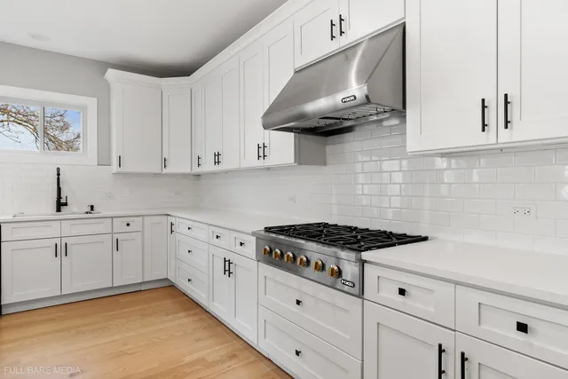 a kitchen with stainless steel appliances a white stove top oven and cabinets