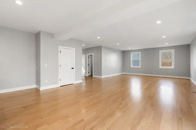 a view of empty room with wooden floor and window