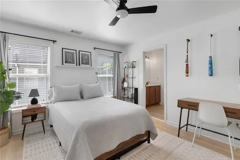 a bedroom with a bed a chair and a large window