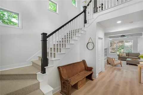 a living room with couches and a dining table with wooden floor
