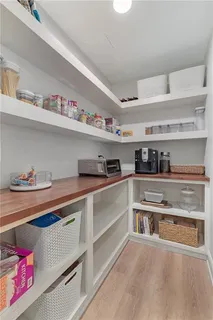 a cabinet with stainless steel appliances granite countertop a sink and wooden cabinets