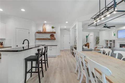 a large kitchen with stainless steel appliances a table and chairs