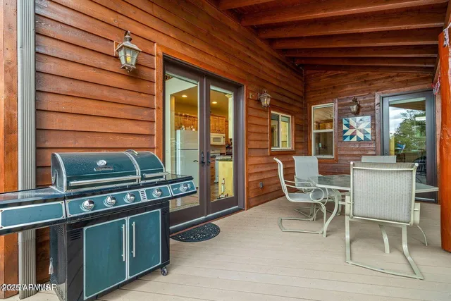 a roof deck with table and chairs and wooden floor
