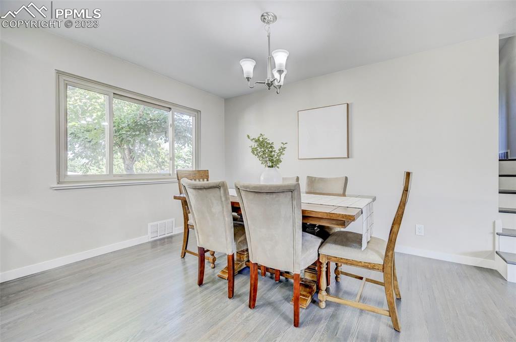 2326 Condor Street Colorado Springs, CO 80909 - Photo 12 of 47 a dining room with furniture a chandelier and wooden floor