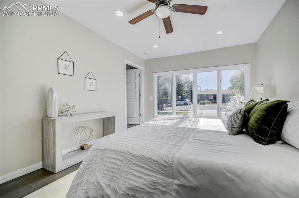 2326 Condor Street Colorado Springs, CO 80909 - Photo 19 of 47 a spacious bedroom with a bed a couch and large window