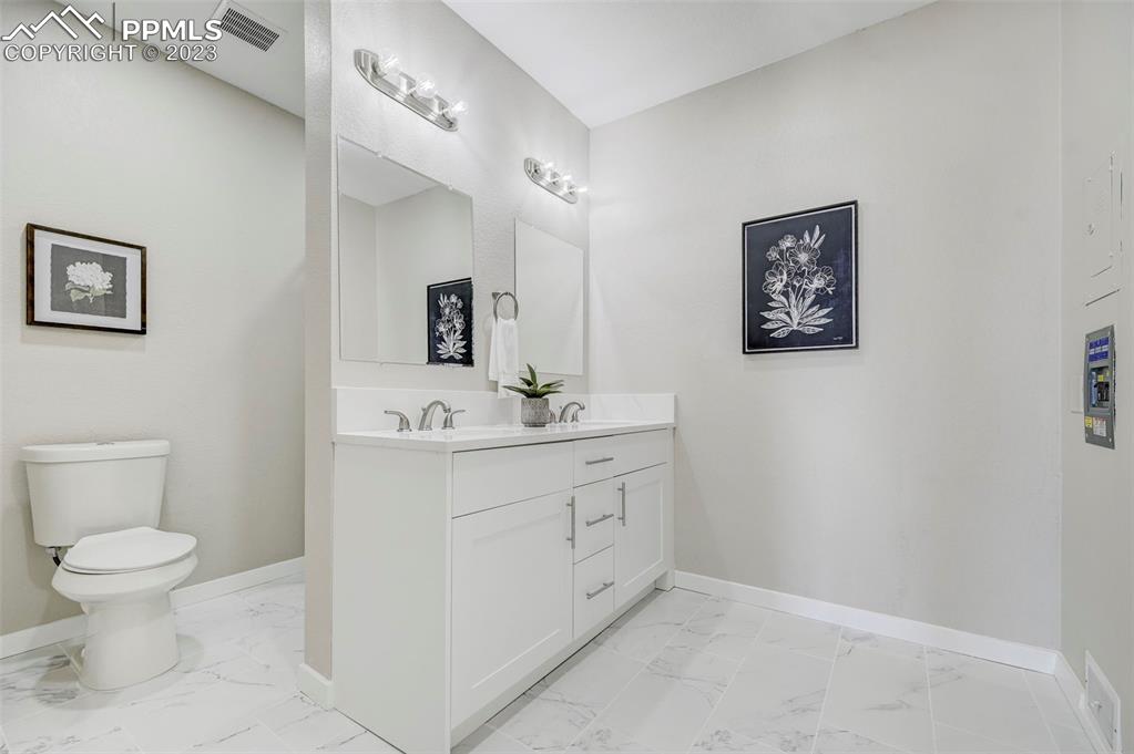 2326 Condor Street Colorado Springs, CO 80909 - Photo 21 of 47 a bathroom with a toilet sink and mirror