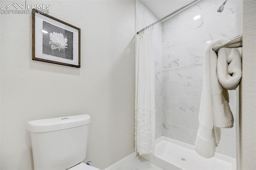 2326 Condor Street Colorado Springs, CO 80909 - Photo 22 of 47 a bathroom with a shower and a toilet