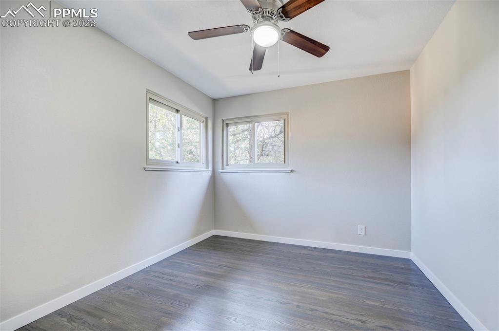 2326 Condor Street Colorado Springs, CO 80909 - Photo 26 of 47 an empty room with wooden floor fan and windows