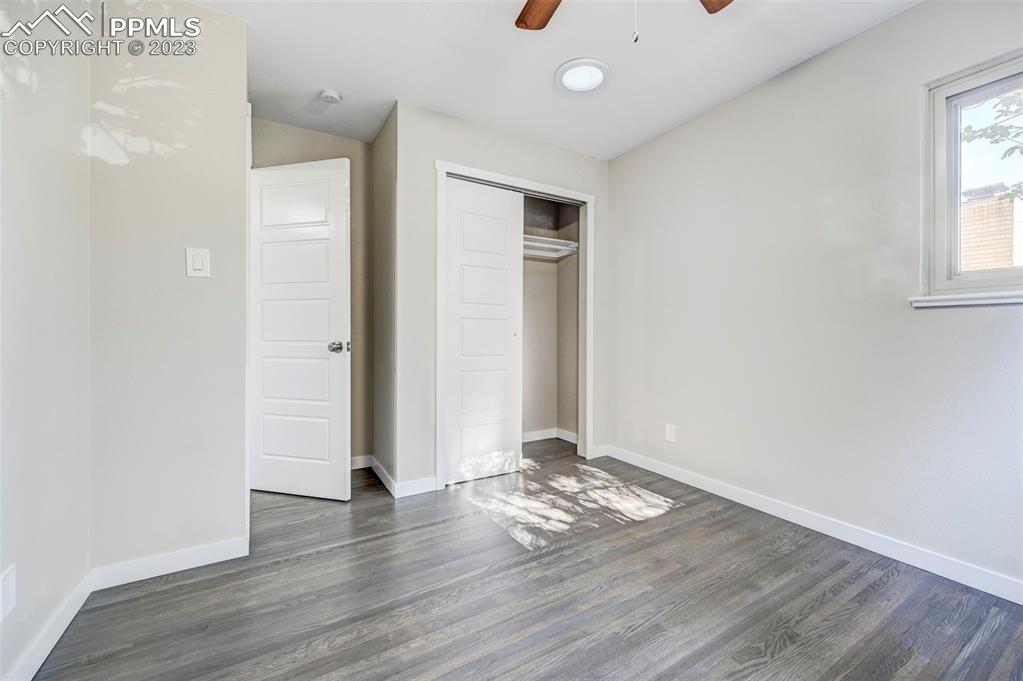 2326 Condor Street Colorado Springs, CO 80909 - Photo 27 of 47 an empty room with wooden floor and windows