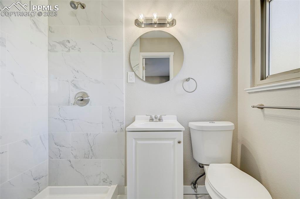 2326 Condor Street Colorado Springs, CO 80909 - Photo 28 of 47 a bathroom with a toilet sink and mirror