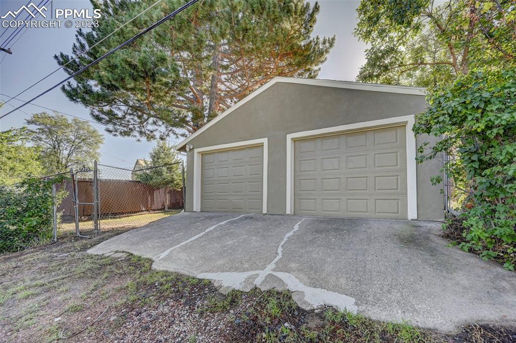 2326 Condor Street Colorado Springs, CO 80909 - Photo 4 of 47 a house with a yard garage and tree