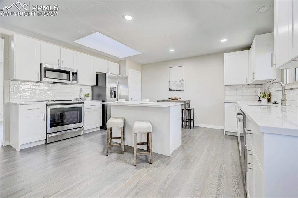 2326 Condor Street Colorado Springs, CO 80909 - Photo 9 of 47 a kitchen with a sink a microwave and cabinets