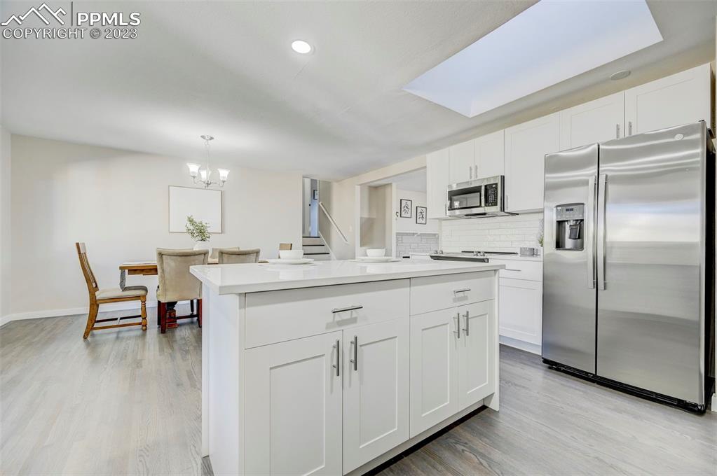 2326 Condor Street Colorado Springs, CO 80909 - Photo 10 of 47 a kitchen with white cabinets and stainless steel appliances