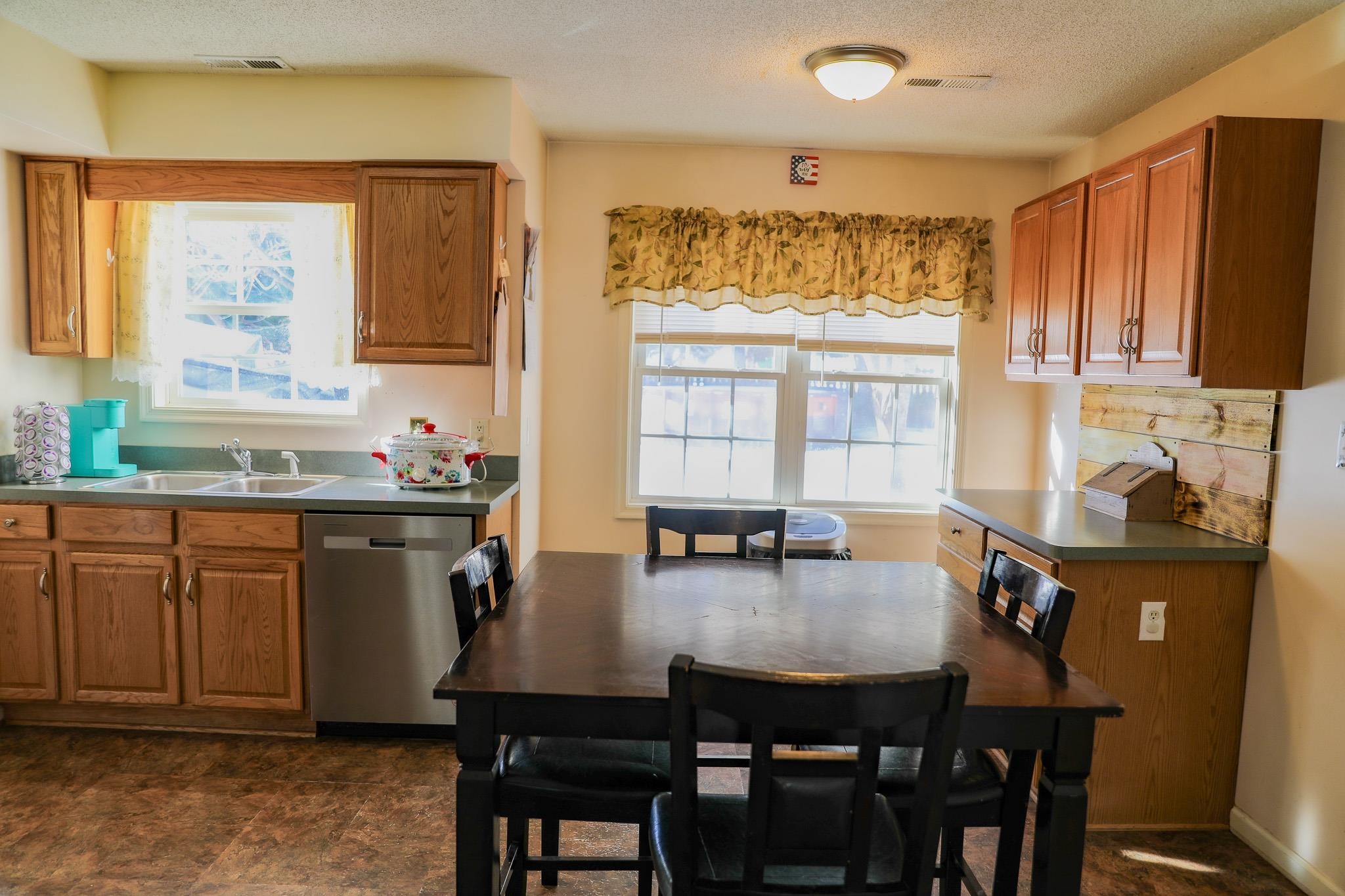 126 Pheasant Run Waynesboro, VA 22980 - Photo 4 of 45 a kitchen with granite countertop a sink dining table and chairs
