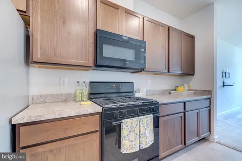 a kitchen with stainless steel appliances granite countertop wooden cabinets and a stove top oven