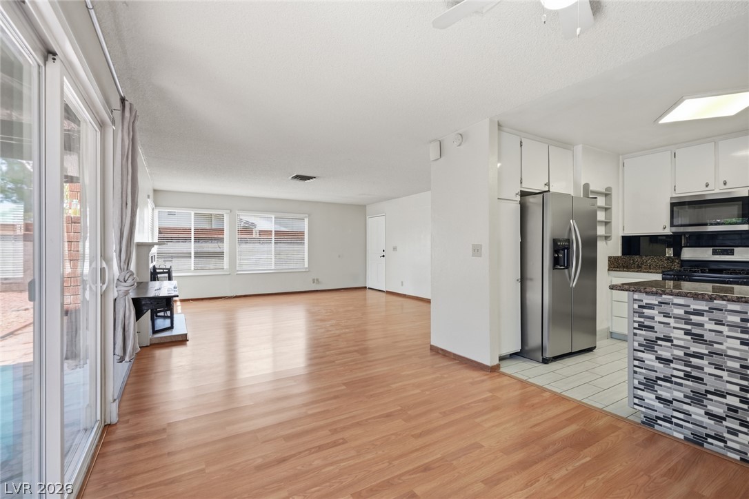 3971 Spring Leaf Drive Las Vegas, NV 89147 - Photo 3 of 48 Wood flooring seamlessly flows through this open concept living area, leading to a functional kitchen.