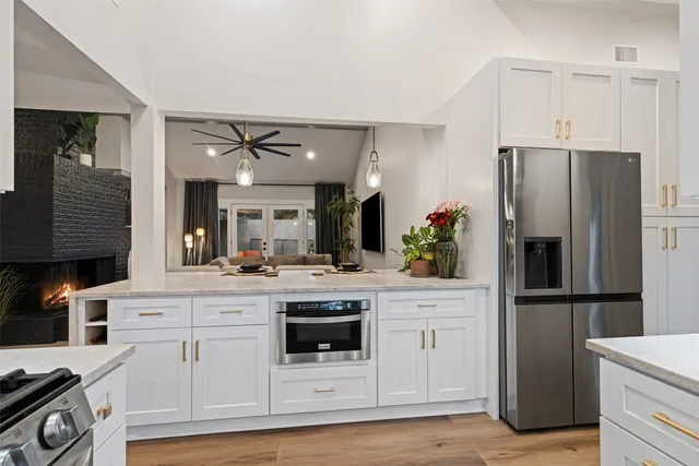 a kitchen with white cabinets and refrigerator