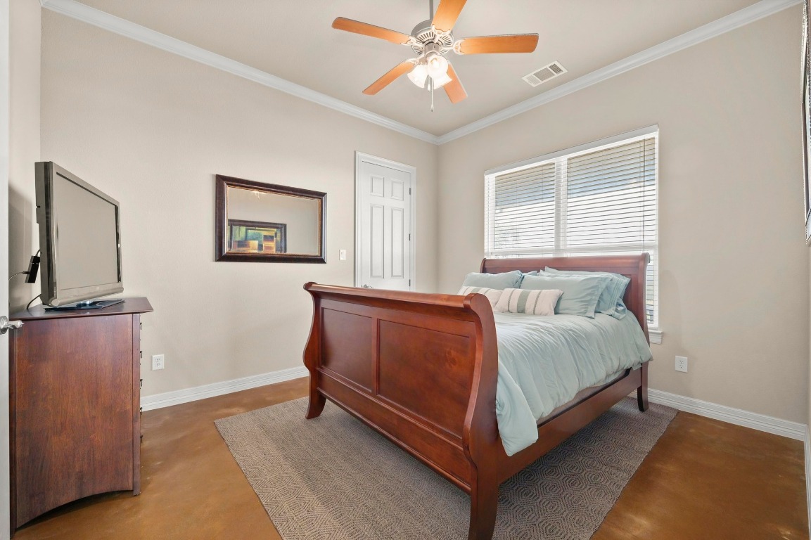 28701 Valley Road Marble Falls, TX 78654 - Photo 17 of 36 a spacious bedroom with a bed and a chandelier