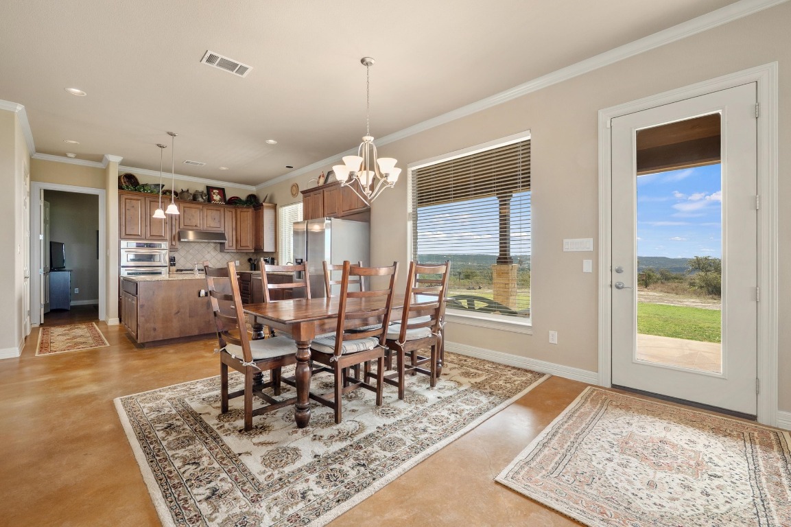 28701 Valley Road Marble Falls, TX 78654 - Photo 7 of 36 a view of a dining room and livingroom with furniture wooden floor a rug a rug a fireplace and a chandelier
