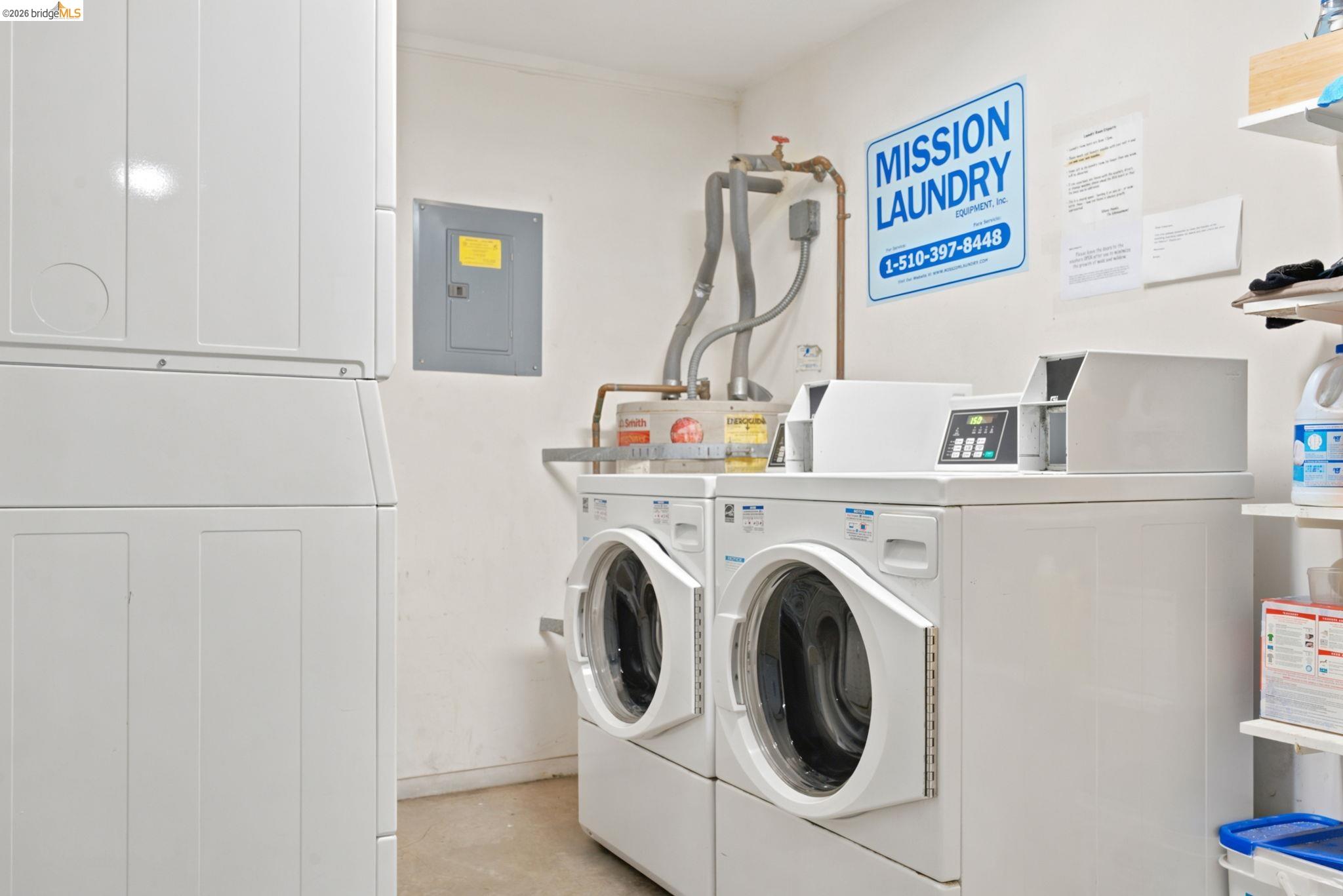 1920 Union Street, Unit 9 Oakland, CA 94607 - Photo 30 of 35 Dedicated laundry area featuring multiple front-load washers and dryers, a utility sink, and wall-mounted shelving
