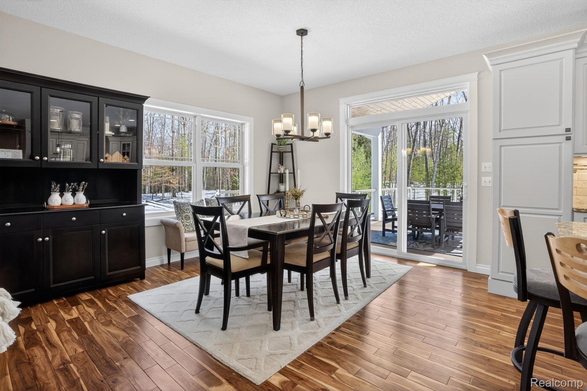 101 Highview Road Traverse City, MI 49696 - Photo 23 of 88 Dining space with dark wood finished floors, a chandelier, healthy amount of natural light, and a textured ceiling