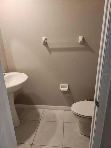 a white toilet sitting next to a white sink and vanity