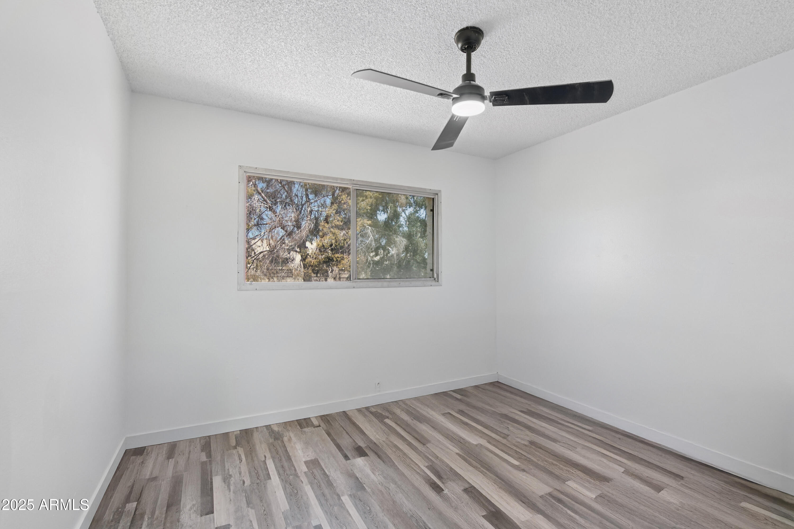 4606 North 19th Avenue Phoenix, AZ 85015 - Photo 21 of 36 an empty room with a window and a ceiling fan