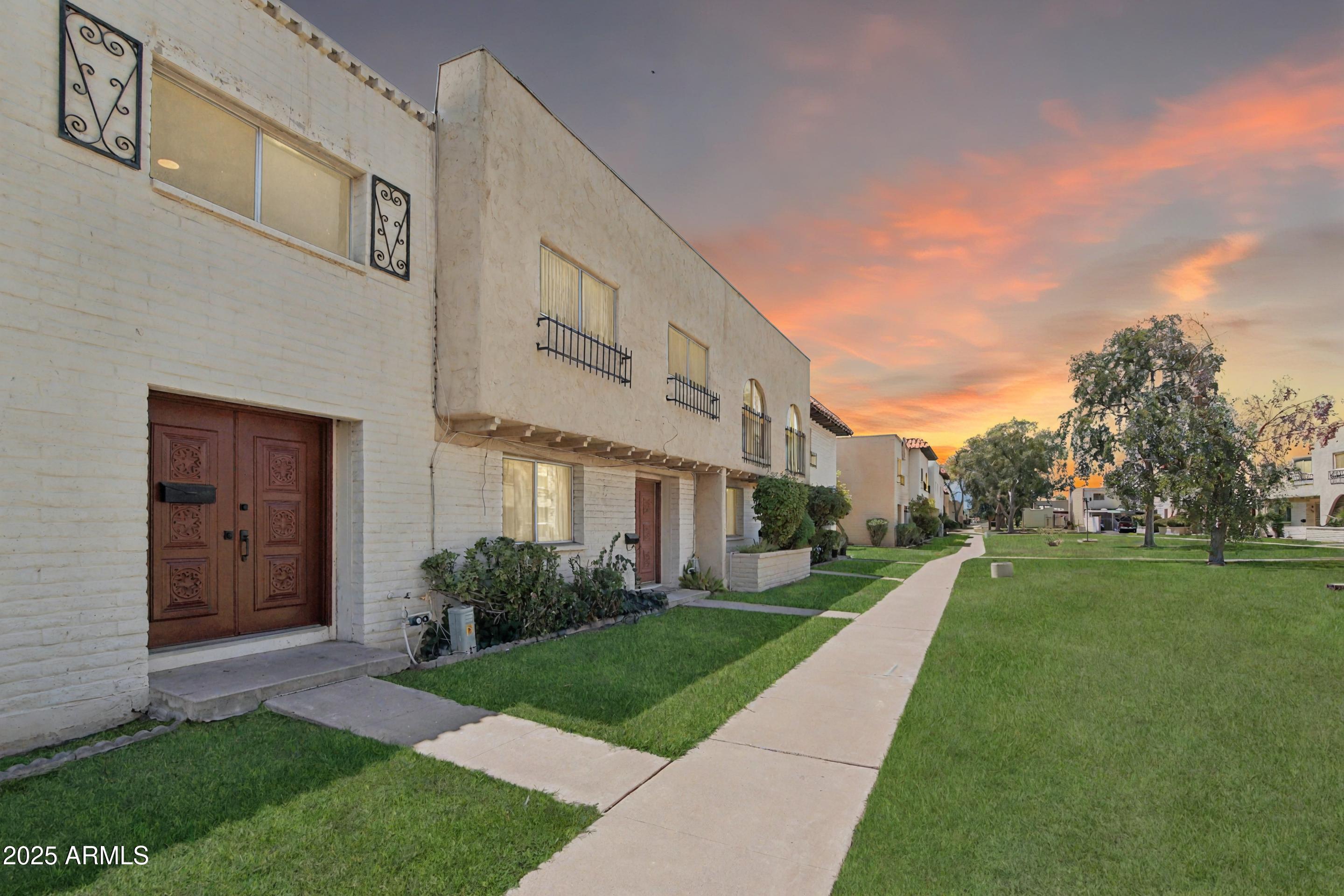 4606 North 19th Avenue Phoenix, AZ 85015 - Photo 2 of 36 a view of a white house next to a yard with big trees