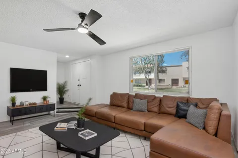 a view of a white house next to a yard with big trees