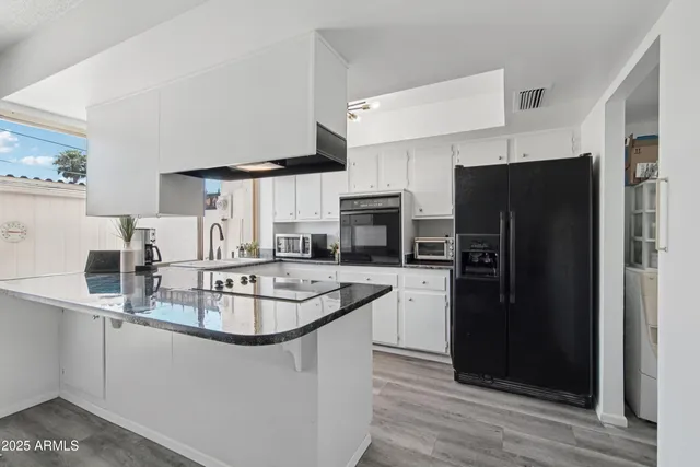 a view of kitchen refrigerator and cabinets