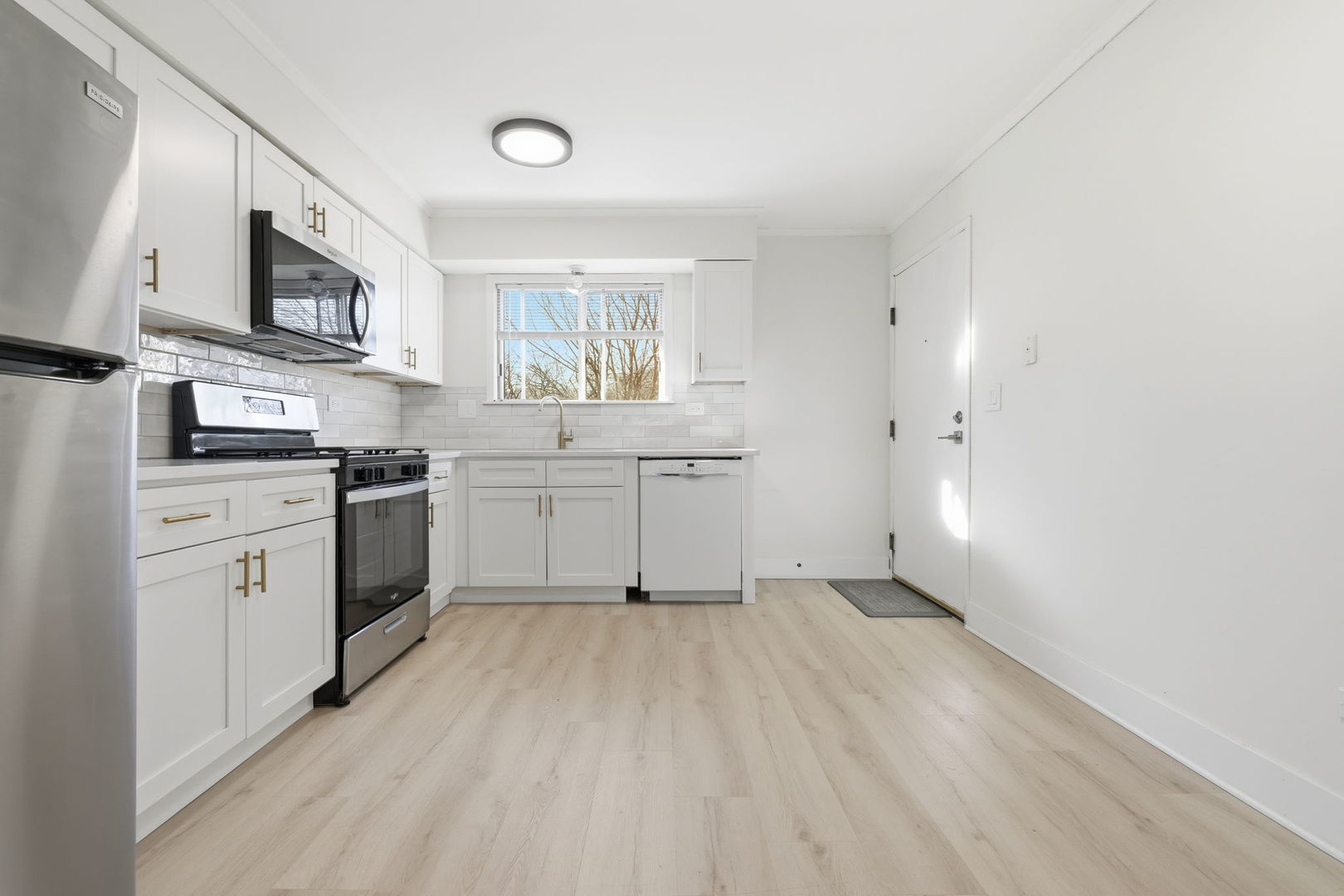 382 Oak Trails Road, Unit 301 Des Plaines, IL 60016 - Photo 9 of 24 a kitchen with stainless steel appliances granite countertop a stove top oven a sink dishwasher and white cabinets with wooden floor