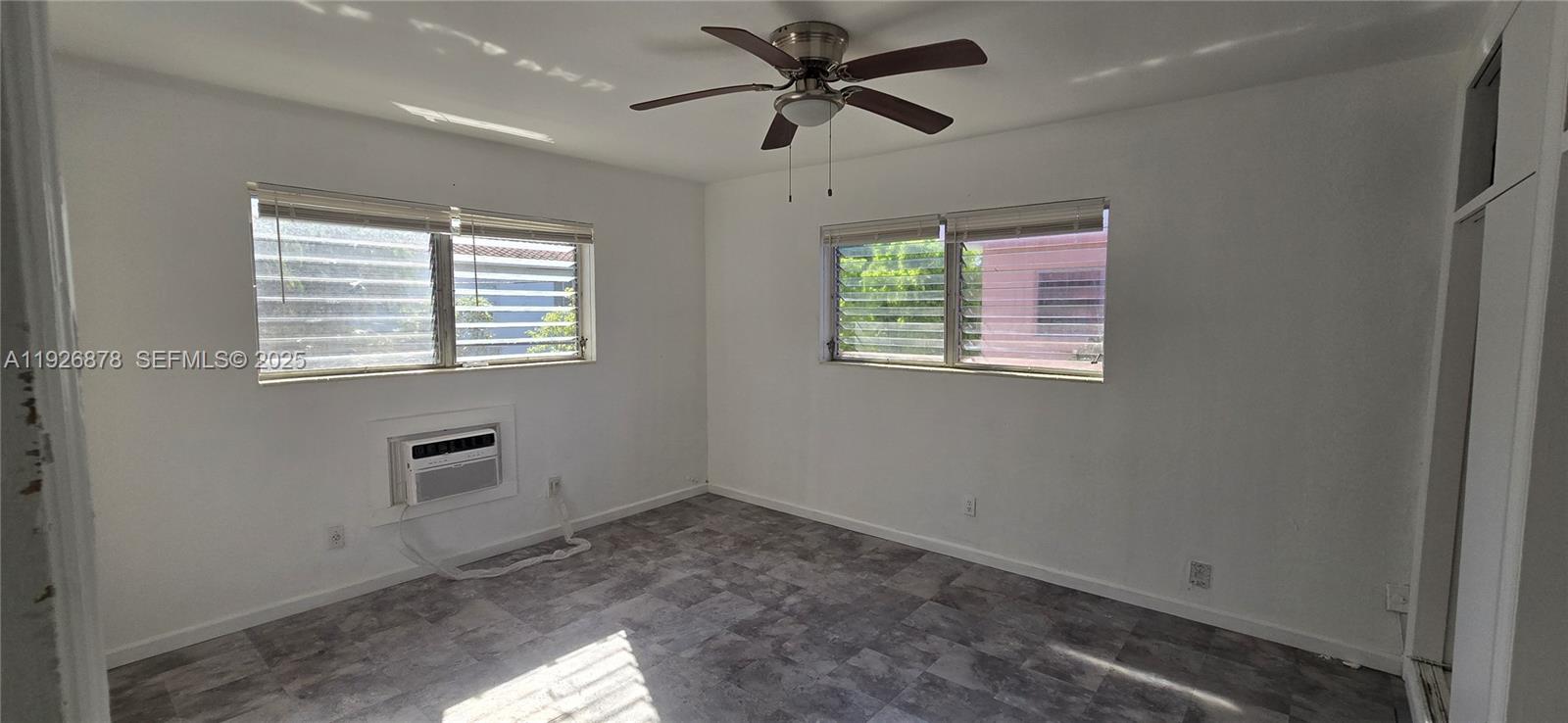 744 85th Street, Unit 1 Miami Beach, FL 33141 - Photo 8 of 13 a view of a livingroom with a ceiling fan & windows