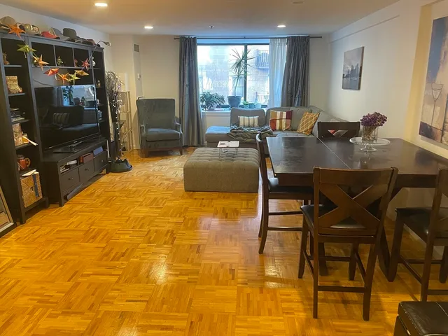 a living room with dining table and a flat screen tv