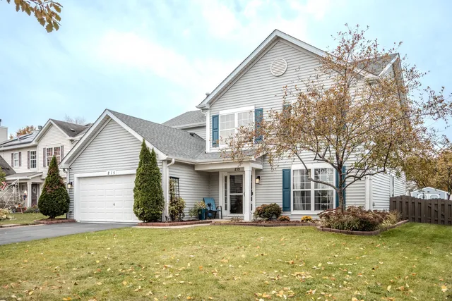 a view of a house with a yard and large tree