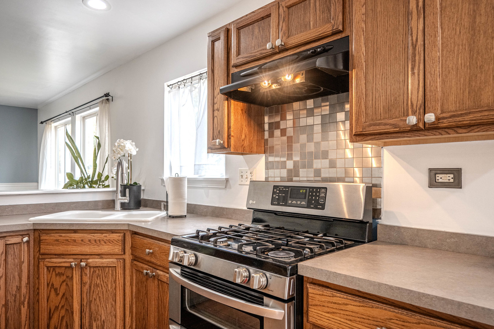 215 Alexis Street Plano, IL 60545 - Photo 16 of 42 a kitchen with granite countertop a stove and a sink