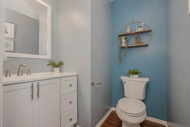 a bathroom with a toilet sink vanity and mirror