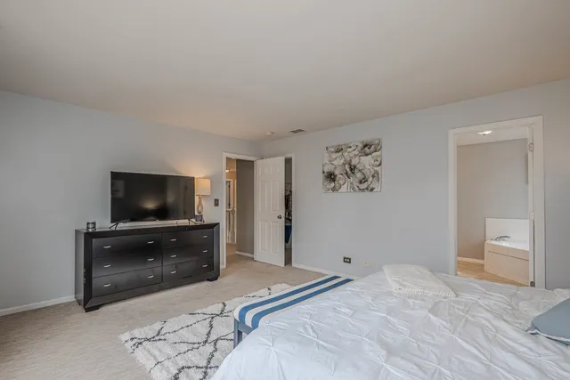 a bedroom with a bed and a flat screen tv on a dresser