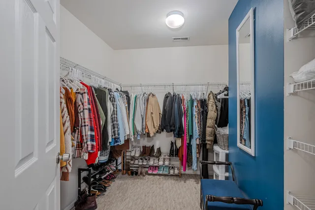 a view of walk in closet with clothes