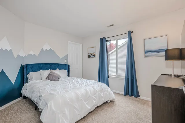 a bedroom with a large bed and a flat tv screen on a dresser