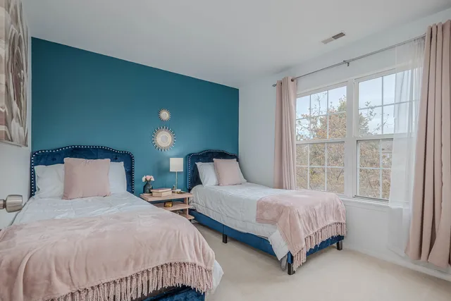 a bedroom with two beds and a large window