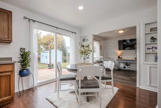 a living room with furniture a large window and wooden floor