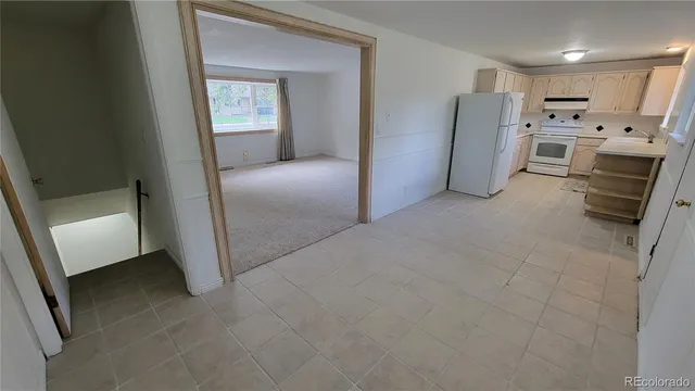 a view of a refrigerator in kitchen and livingroom