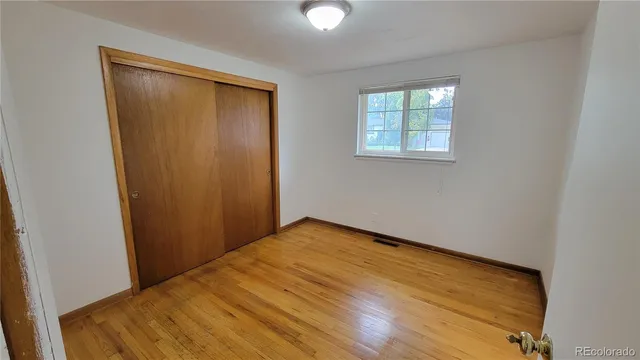 an empty room with windows and closet
