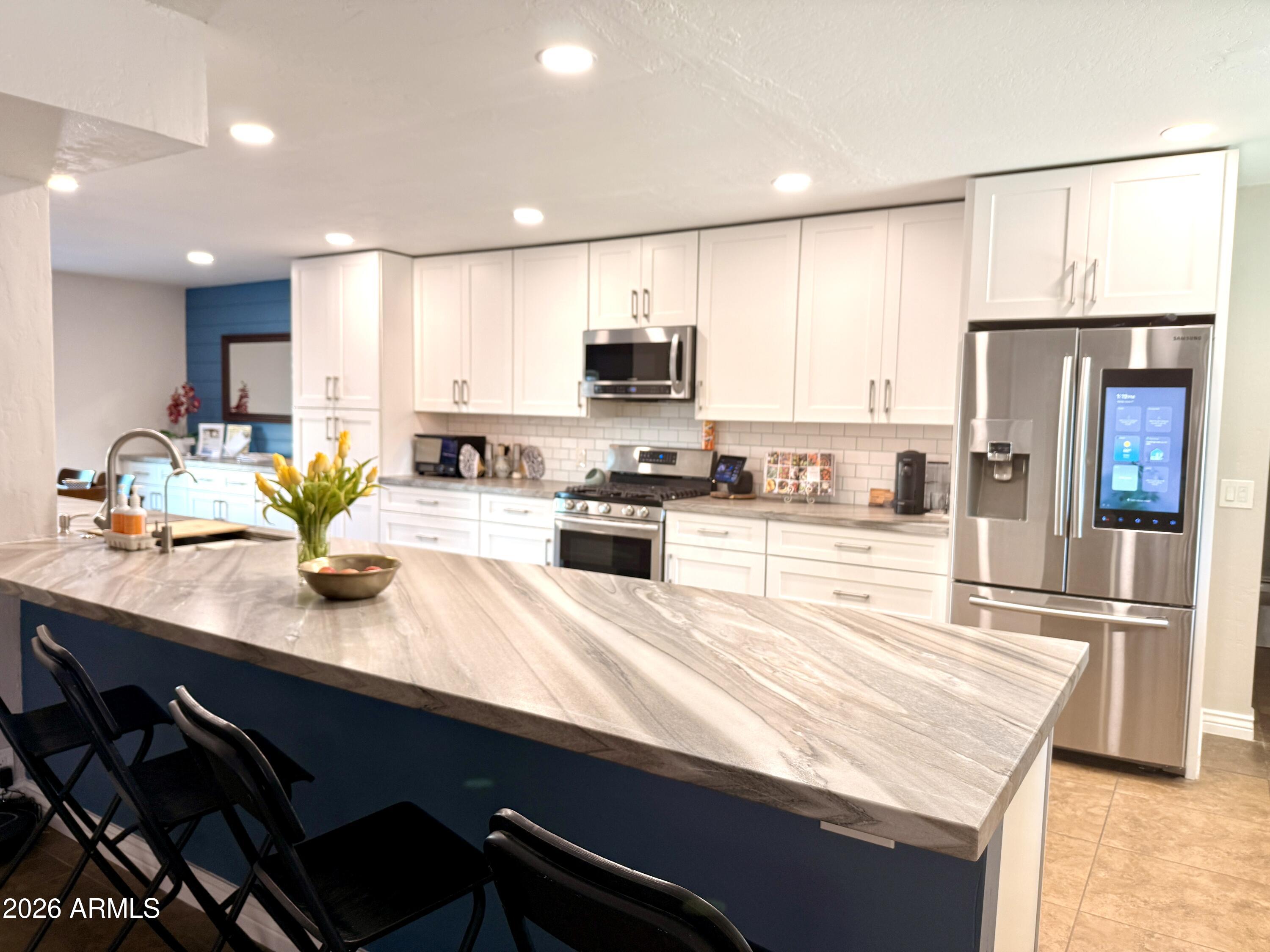 3541 East Cannon Drive Phoenix, AZ 85028 - Photo 15 of 42 a kitchen with kitchen island granite countertop a sink chairs and cabinets
