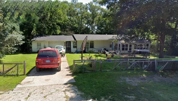a front view of a house with a garden and sitting area