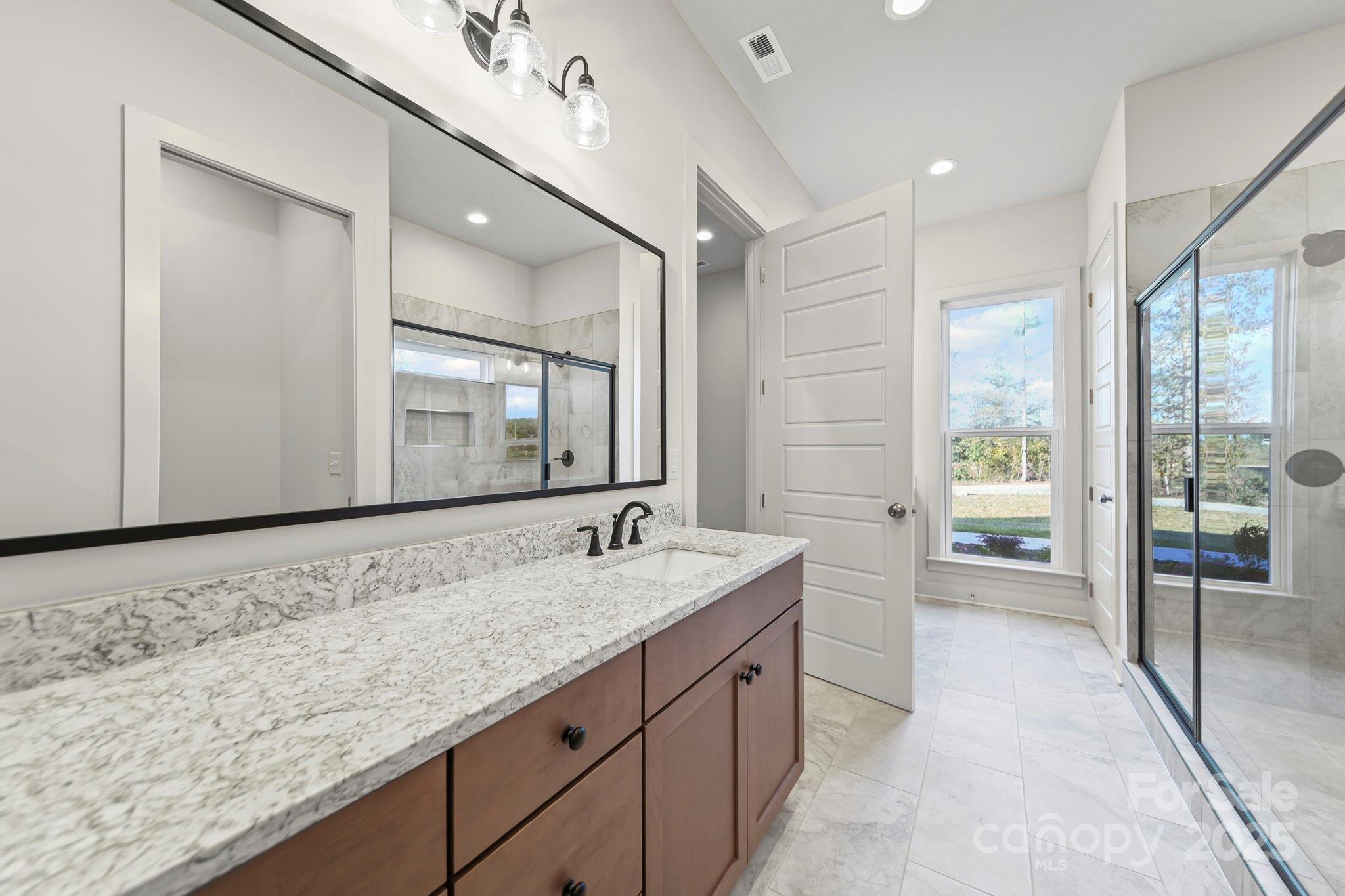 2417 Plyler Mill Road Monroe, NC 28112 - Photo 13 of 34 a spacious bathroom with a granite countertop sink mirror and bathtub